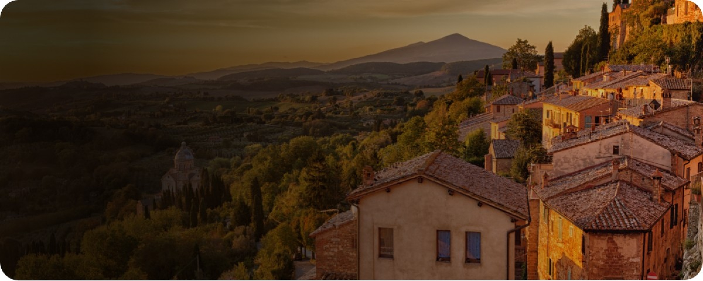 Fotografia dall'alto che inquadra i tetti di un paese italiano durante un tramonto